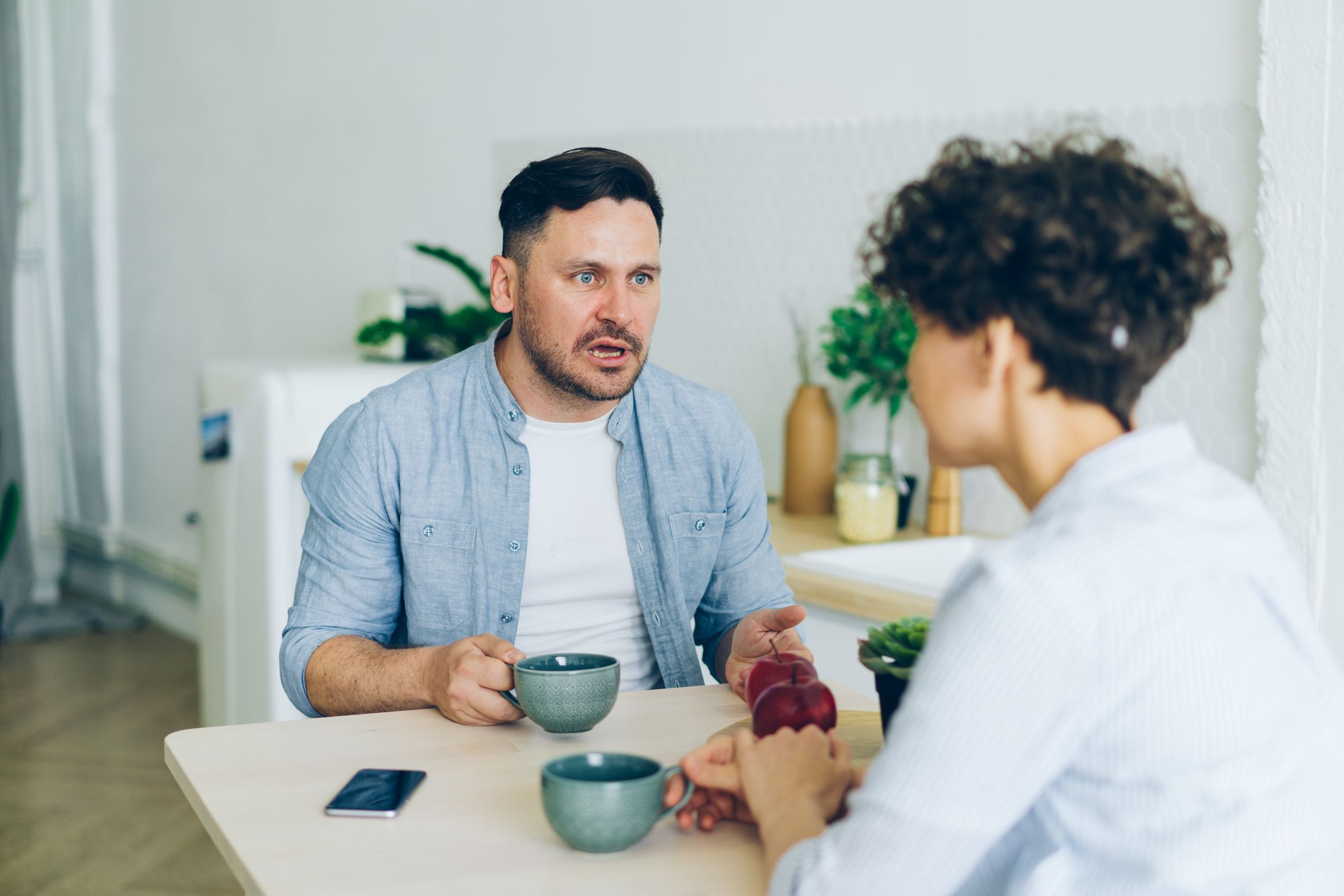 A couple in conversation at the kitchen table