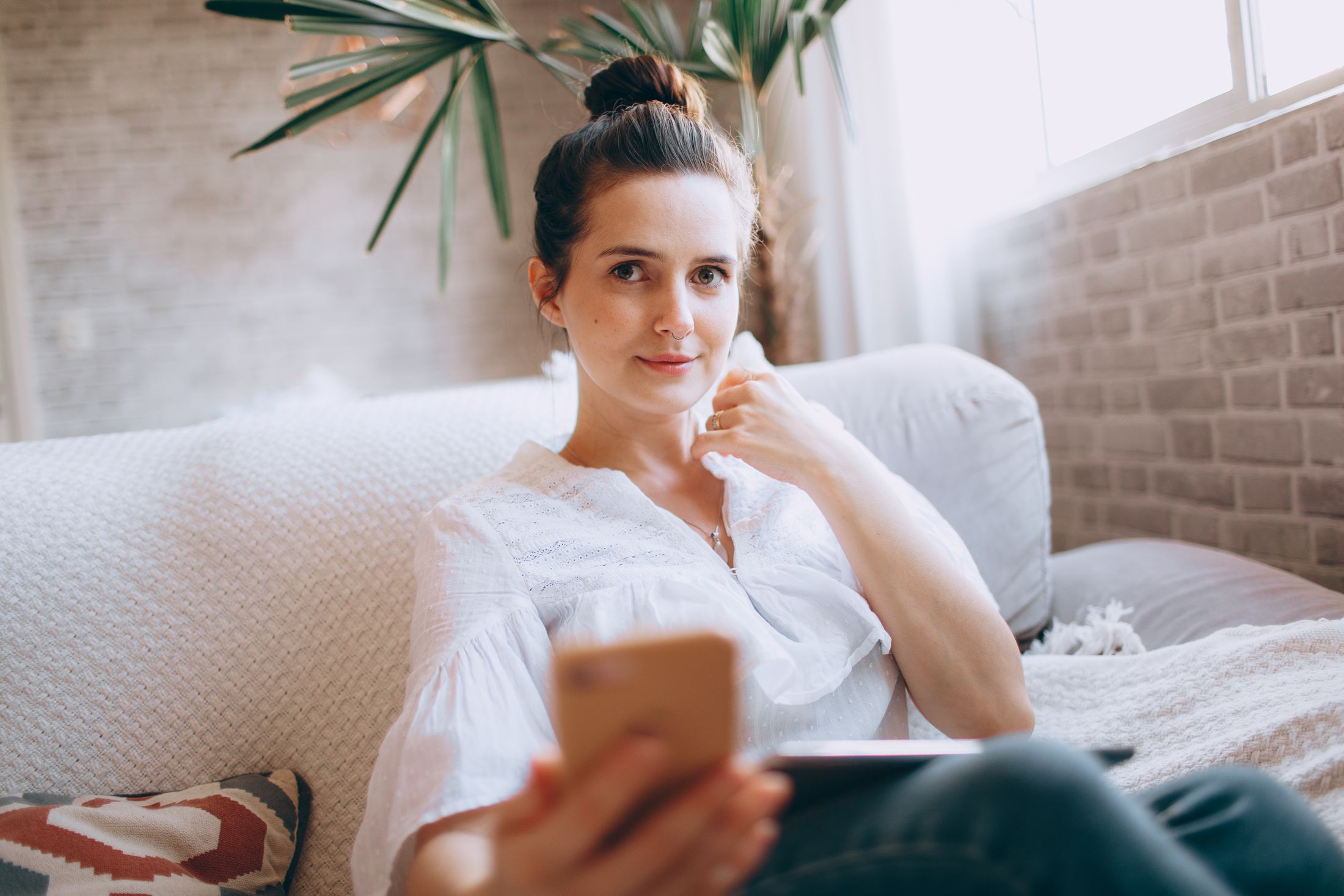 A young woman relaxing on a sofa with her phone