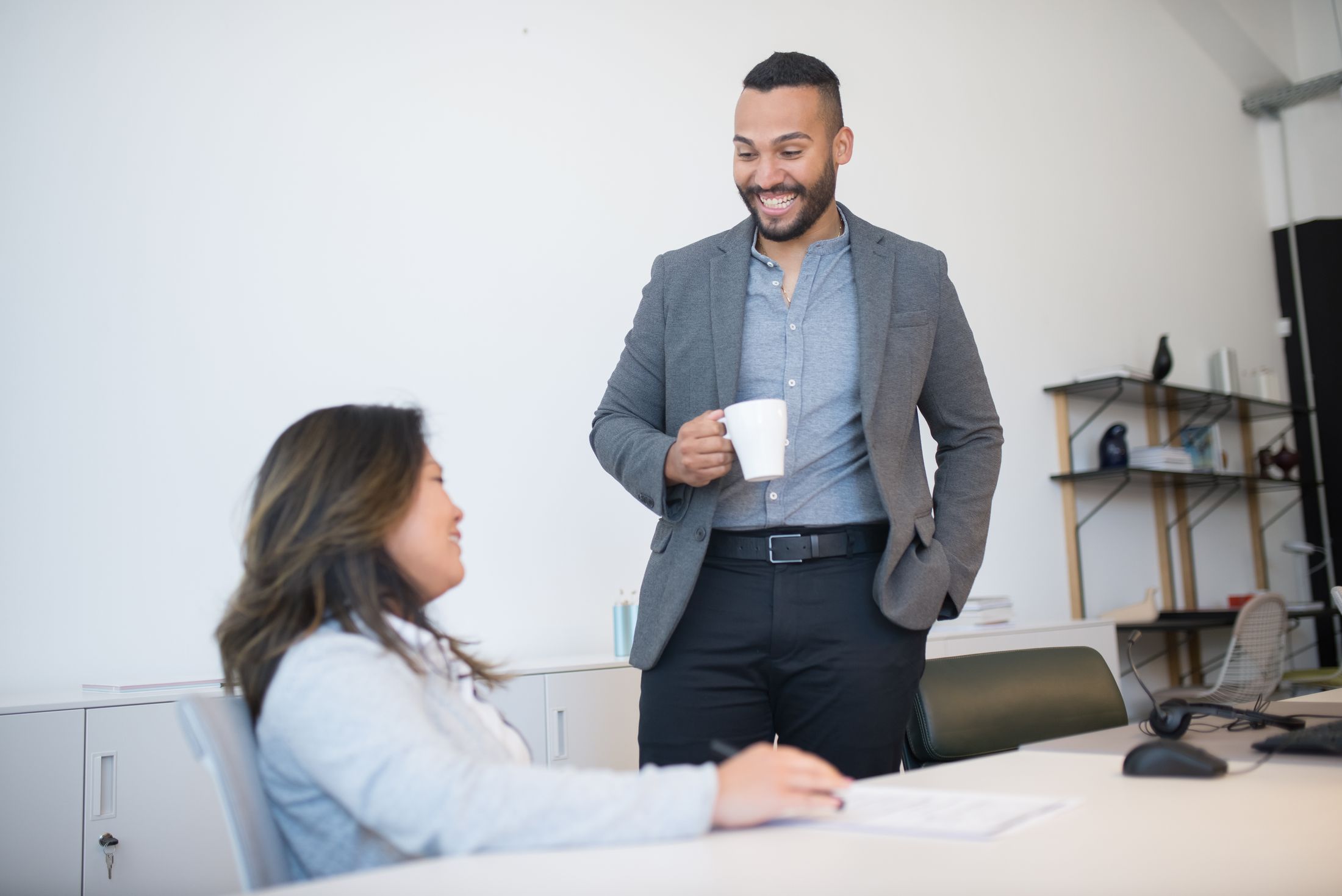 Two professionals smiling during a conversation